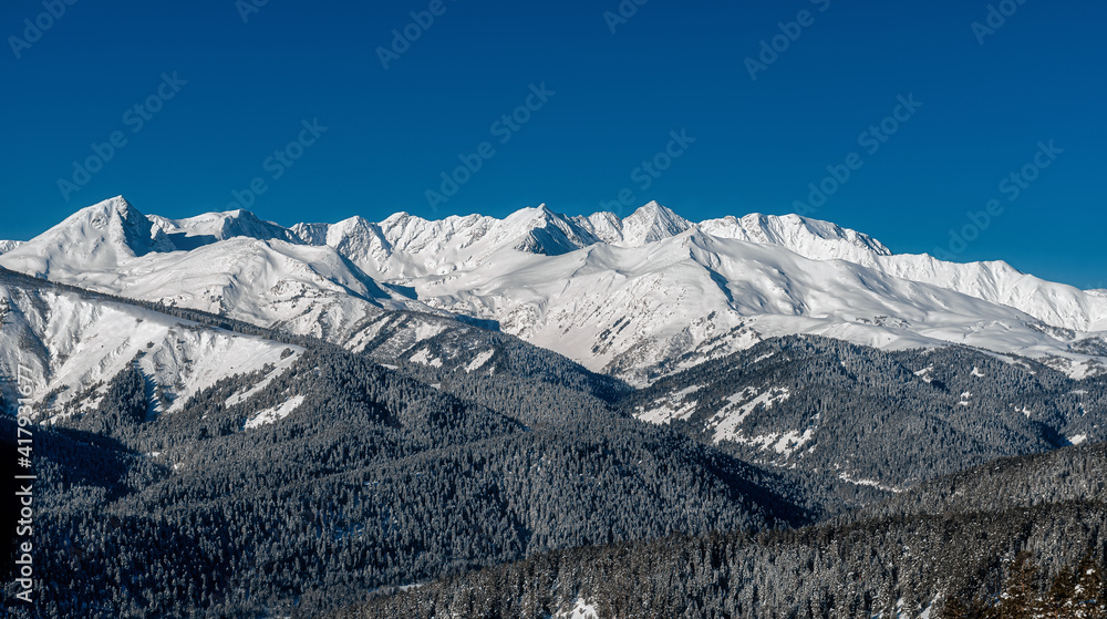 Caucasus mountains. Winter mountain landscape. Trees in the snow on the mountainside. Background