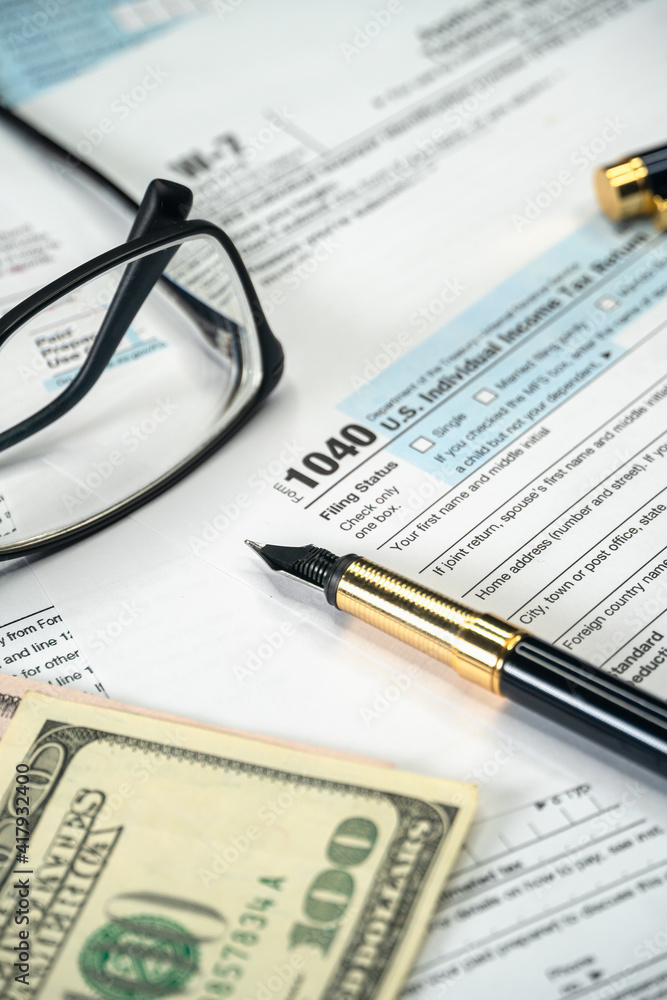 Filling US tax form 1040. Tax time for USA business income return tax and irs. Vertical photo Filling US tax form 1040. Tax time for USA business income return tax and irs. Vertical photo