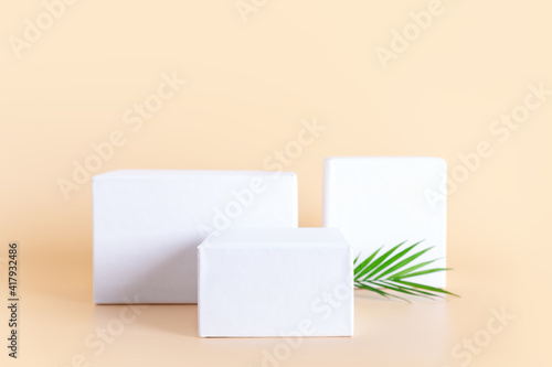 White empty podium stands on neutral beige background. © photopixel