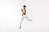 Fitness woman in sportswear running over white background in studio