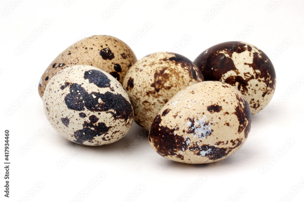 bunch of quail eggs on a white background (not isolated).