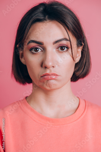 Portrait of sad upset young woman with bright makeup on pink background © Анастасия Каргаполов