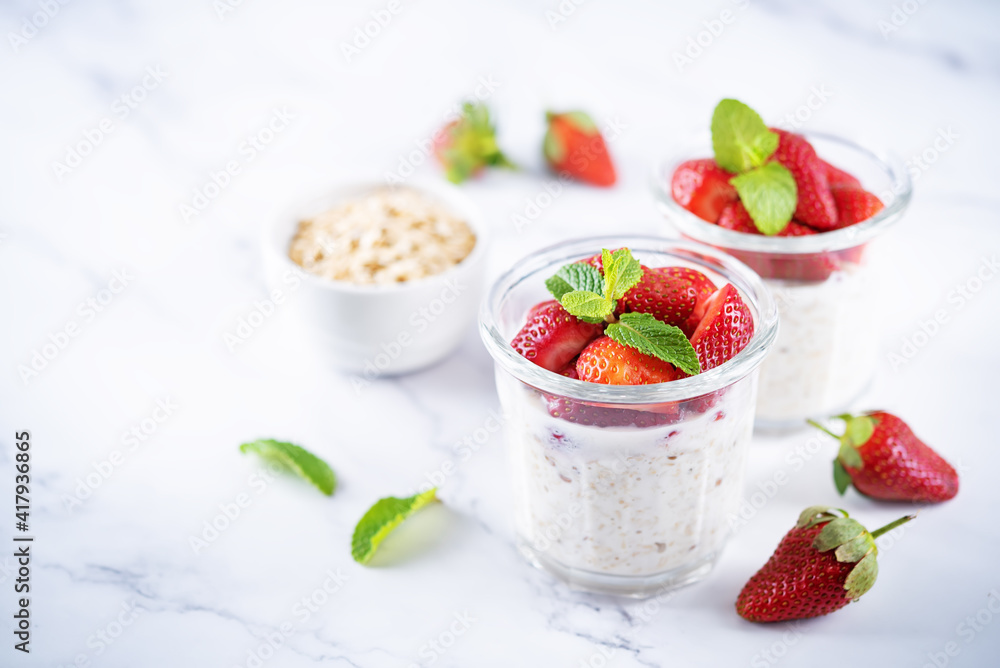 Oatmeal porridge with milk and fresh strawberries in a glass Oatmeal porridge with milk and fresh strawberries in a glass