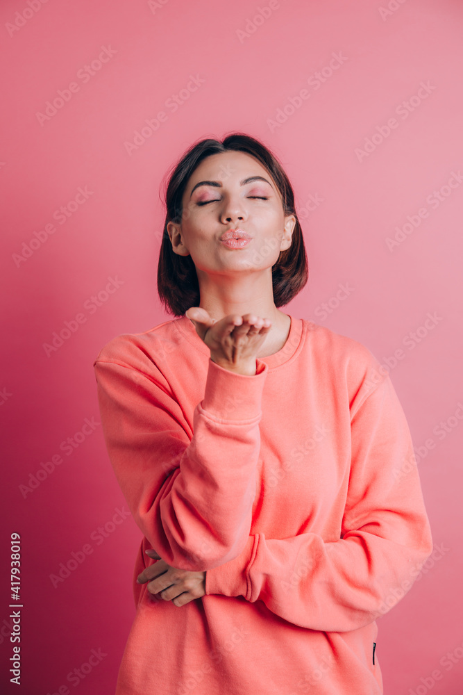 Woman wearing casual sweater on background smiling looking at the camera blowing a kiss with hand on air being lovely Woman wearing casual sweater on background smiling looking at the camera blowing a kiss with hand on air being lovely