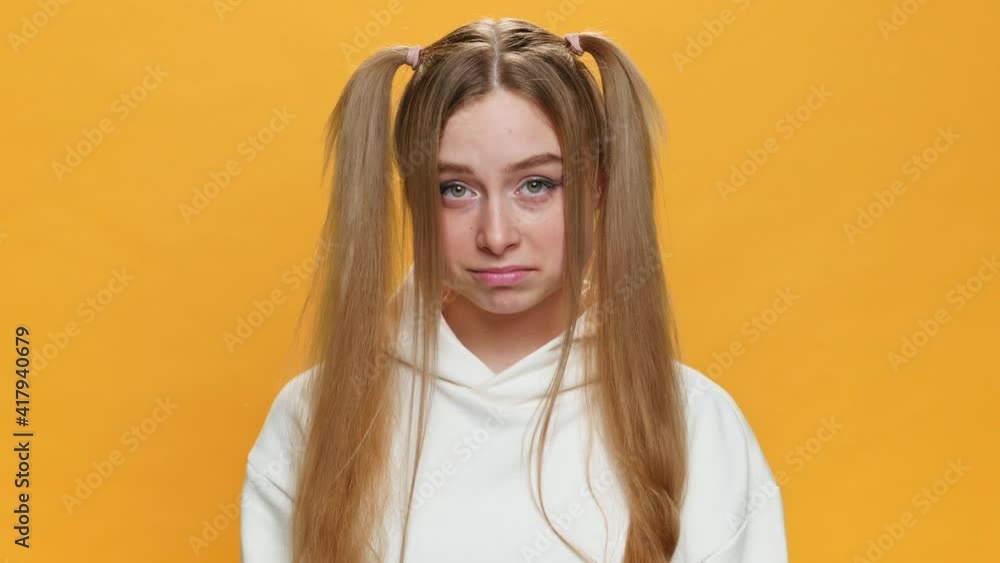 Think About it Surprised Teenager Girl Showing Emotion, Really? sing Gesture with Index Finger to Temple of Head in funny ponytails on Yellow Background. Fashion. Emotions People. Lifestyle Think About it Surprised Teenager Girl Showing Emotion, Really? sing Gesture with Index Finger to Temple of Head in funny ponytails on Yellow Background. Fashion. Emotions People. Lifestyle