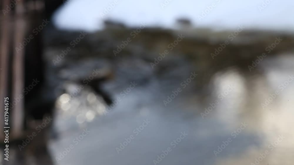 Blurred water flows near the dam on snowy shore background, view from above Blurred water flows near the dam on snowy shore background, view from above