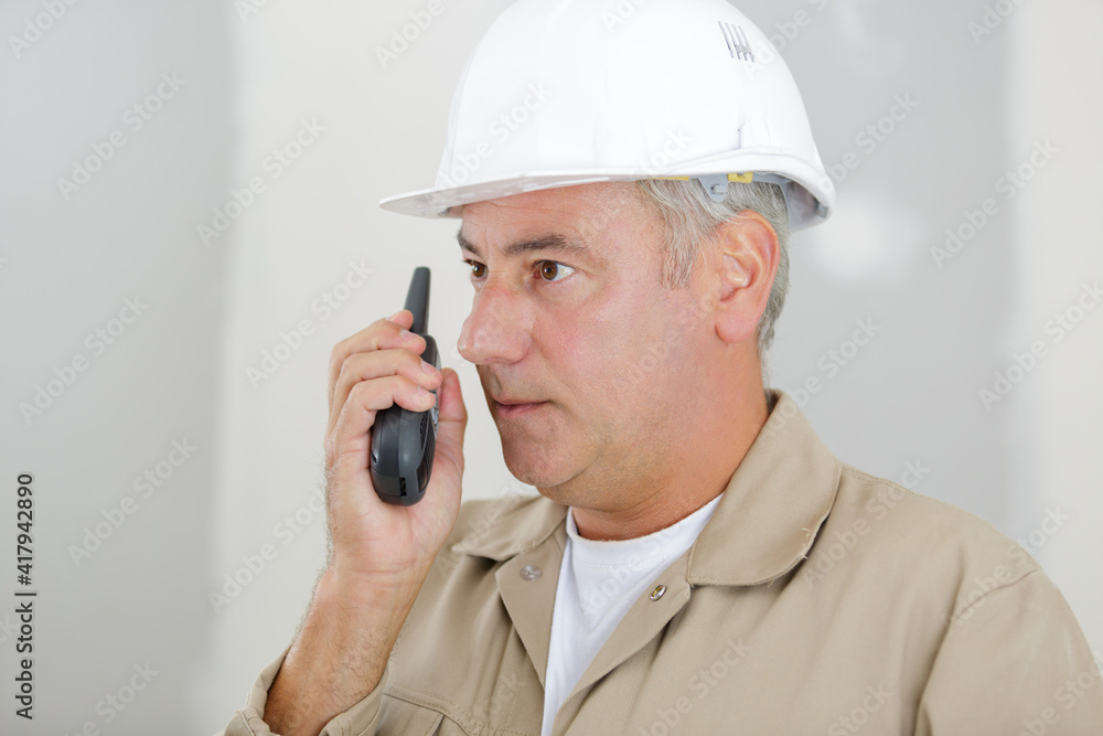 man in work uniform talking into walkie talkie man in work uniform talking into walkie talkie
