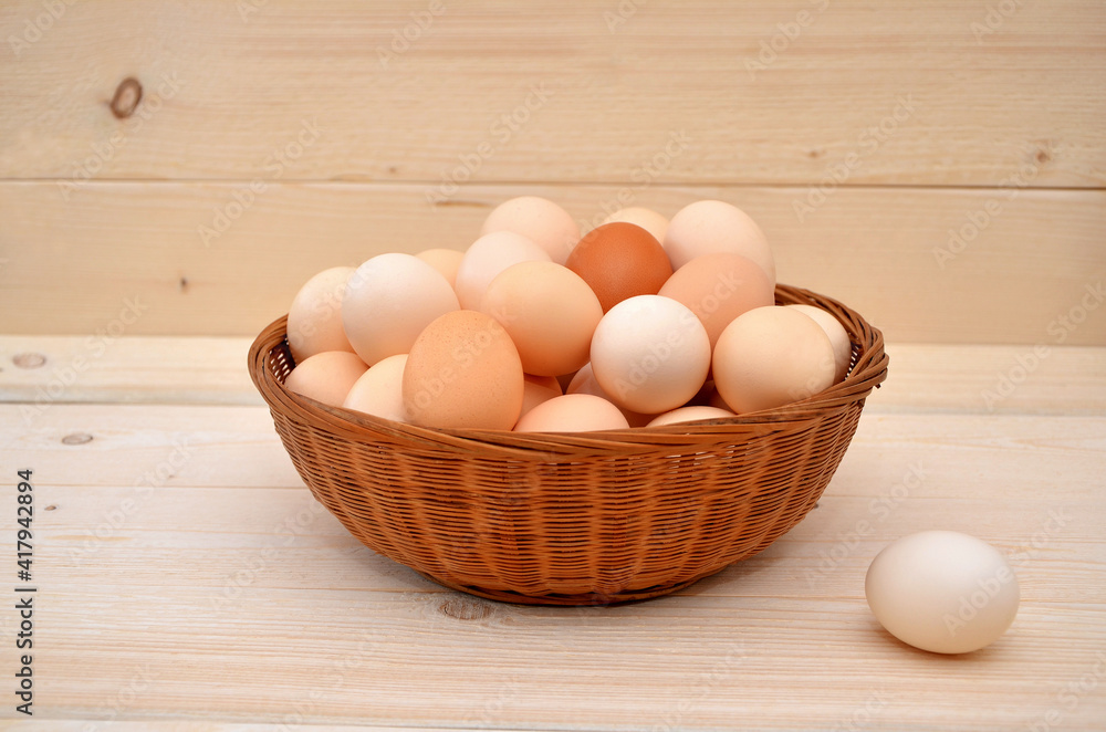 basket with chicken eggs on wooden background basket with chicken eggs on wooden background