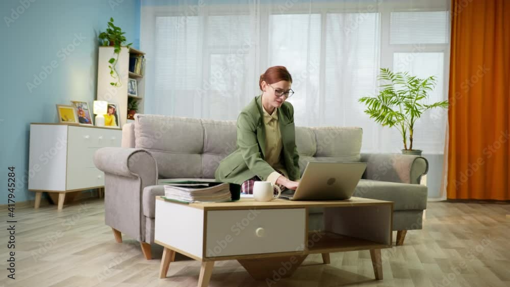 home office, young charming woman in jacket and pajamas talks to boss via video call on laptop and pulls arms up enjoying rest after work sitting on couch at home, remote work home office, young charming woman in jacket and pajamas talks to boss via video call on laptop and pulls arms up enjoying rest after work sitting on couch at home, remote work