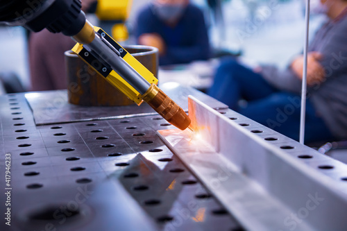 Fotografie Arc welding robot. Example of working with a laser pointer