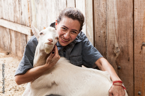 Veterinária abraça cabra e juntas posam para a foto. photo