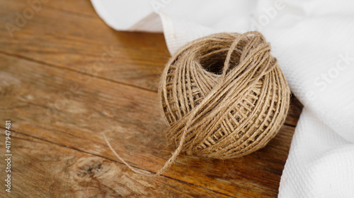 Skeins of jute rope on wooden table flat lay background with copy space. A ball of twine on a wooden background.