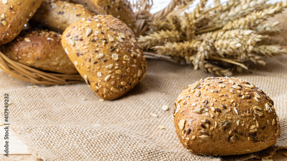 Home baked bread. Rye bakery with crusty loaves and crumbs. Fresh rustic traditional bread with wheat grain ear or spike plant on natural cotton background. Design element for bakery product label. Home baked bread. Rye bakery with crusty loaves and crumbs. Fresh rustic traditional bread with wheat grain ear or spike plant on natural cotton background. Design element for bakery product label.