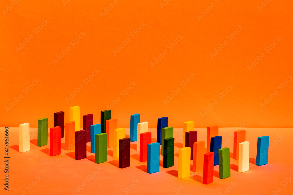 Arrangement of colorful toy blocks in a row on orange background