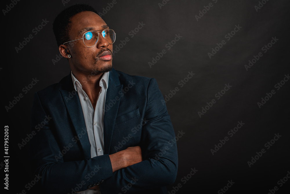 portrait of attractive, beautiful, serious and stylish professional African American businesswoman in dark suit and white shirt isolated on dark background. Low key. Selective focus portrait of attractive, beautiful, serious and stylish professional African American businesswoman in dark suit and white shirt isolated on dark background. Low key. Selective focus