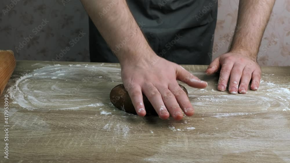 Young chef Covers baking paper over the dough and then rolls it out with a rolling pin. Baking concept Young chef Covers baking paper over the dough and then rolls it out with a rolling pin. Baking concept