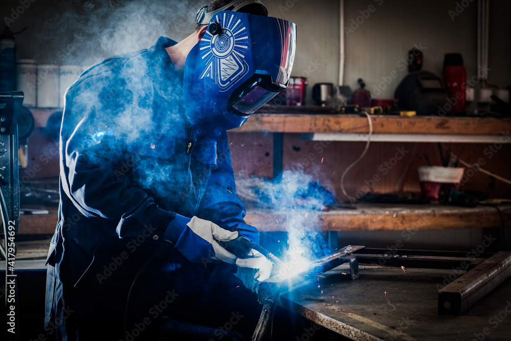 worker grinding a metal plate worker grinding a metal plate
