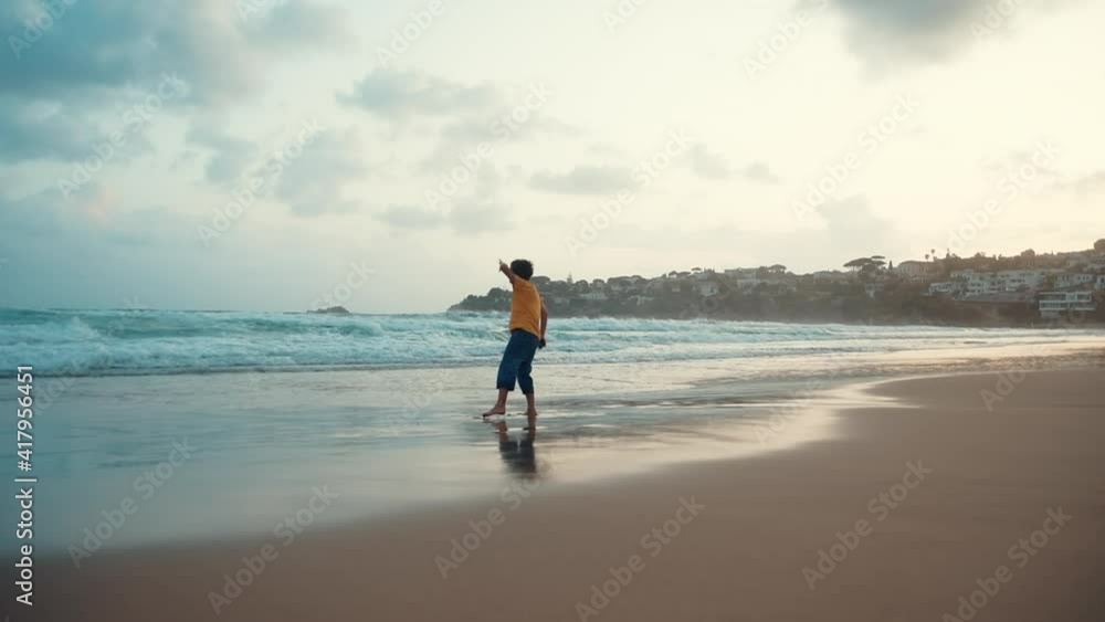 Joyful guy spending evening at sea surf. Carefree boy resting at coastline. Joyful guy spending evening at sea surf. Carefree boy resting at coastline.