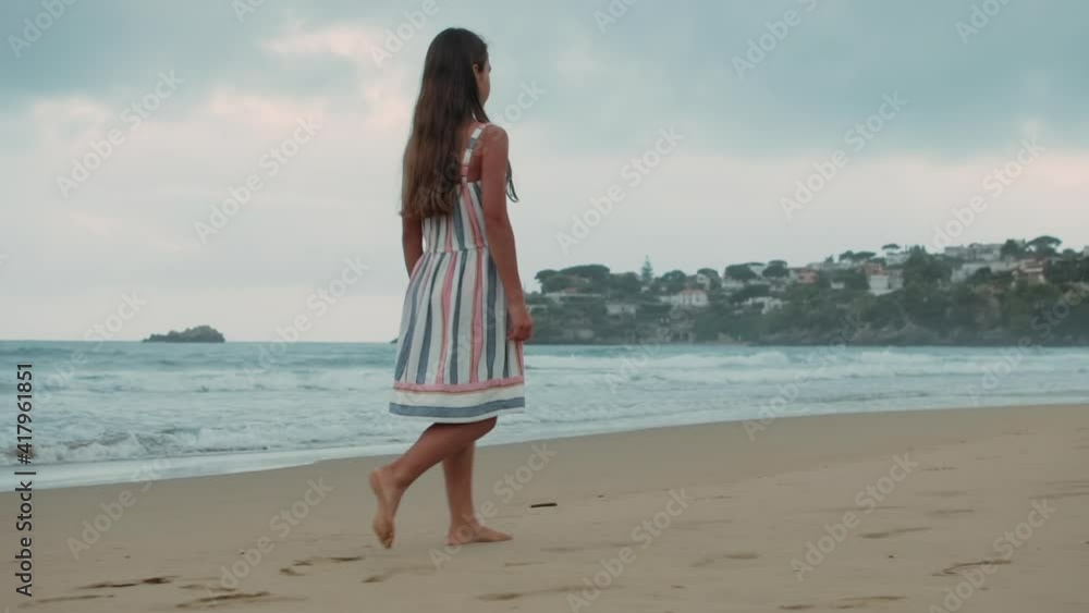 Carefree girl resting at sand beach. Young woman walking at seaside in sunset. Carefree girl resting at sand beach. Young woman walking at seaside in sunset.