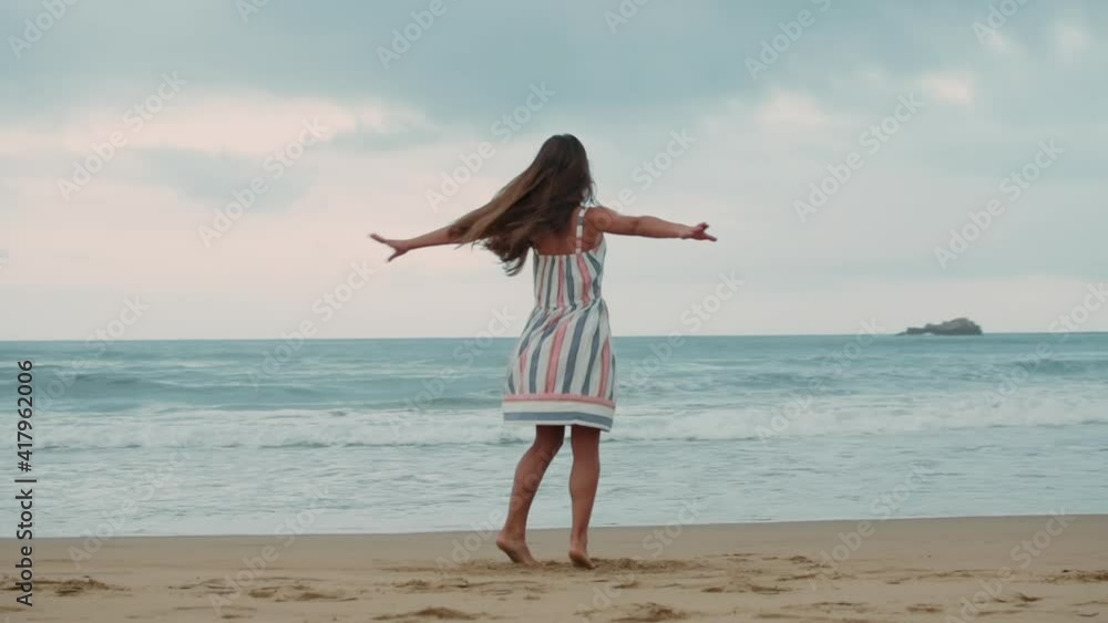 Happy girl spending vacation at seashore. Young woman dancing at coastline. Happy girl spending vacation at seashore. Young woman dancing at coastline.