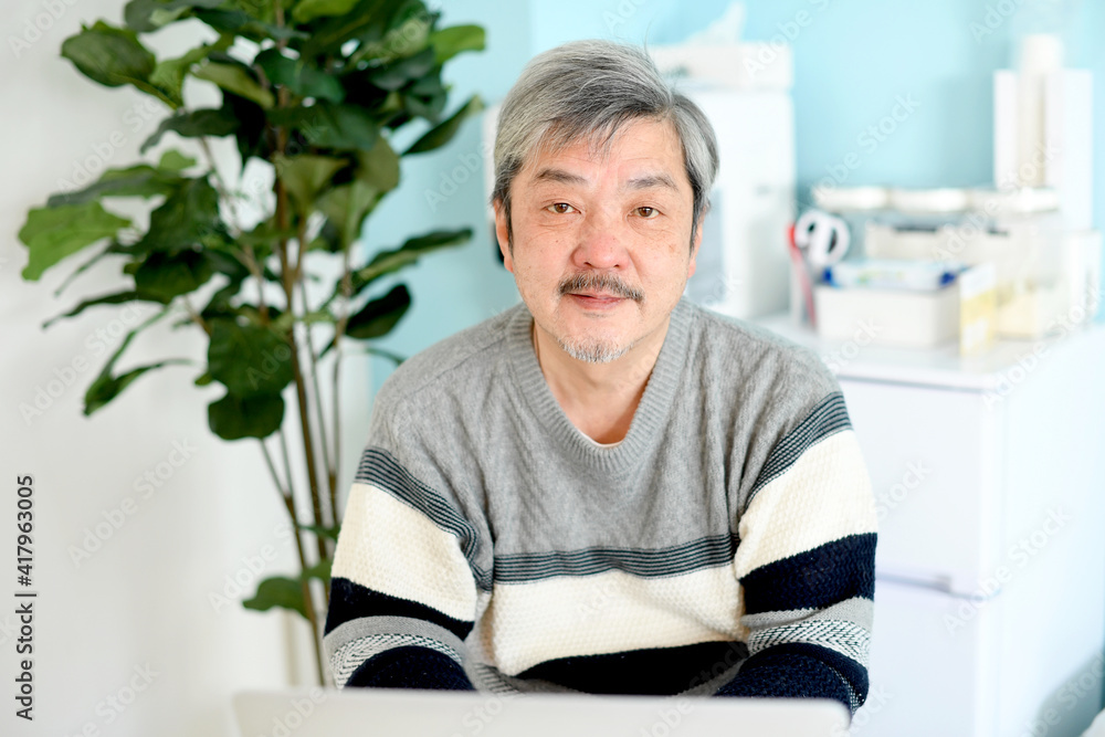 ノートパソコンを操作する高齢者(シニア)の白髪の男性 ノートパソコンを操作する高齢者(シニア)の白髪の男性