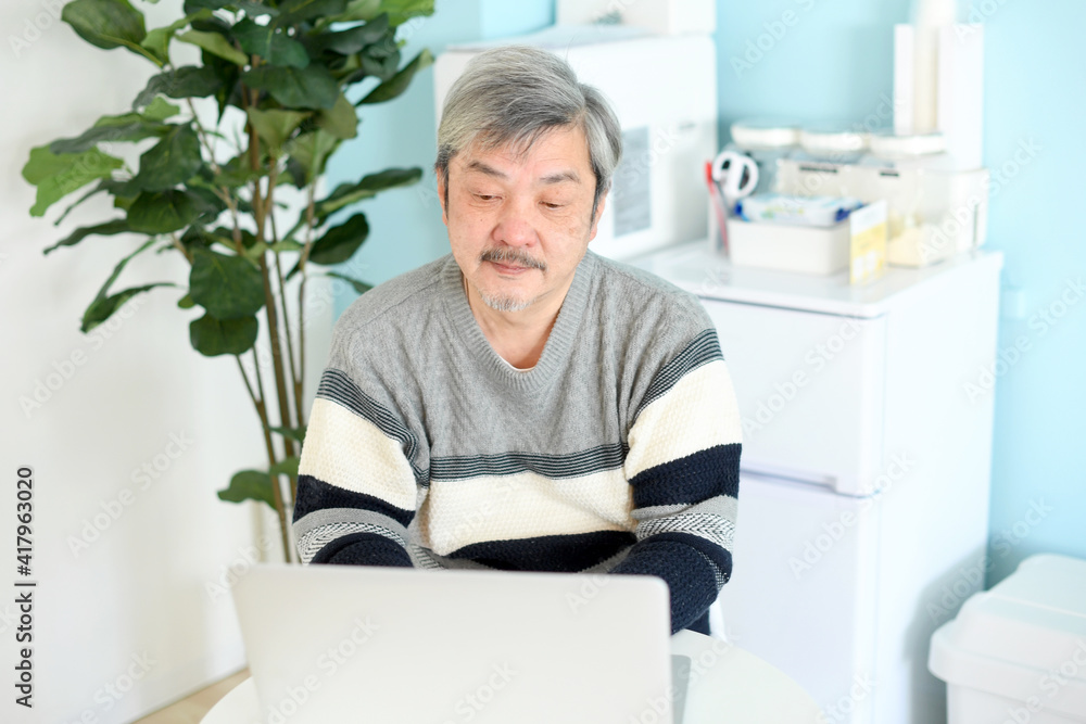 ノートパソコンを操作する高齢者(シニア)の白髪の男性 ノートパソコンを操作する高齢者(シニア)の白髪の男性