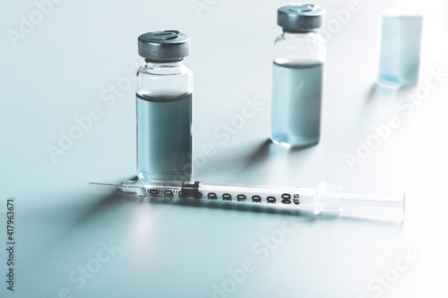 vaccine vials on a blue background. medical concept. Very shallow depth of field. illumination across the frame