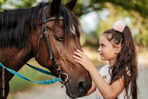 Emotional contact with the horse. Horse riding. The girl rides a horse in the summer. © sergo321