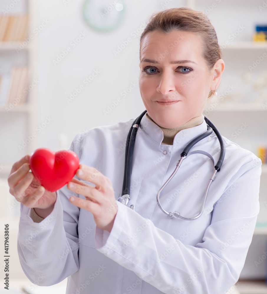 Cardiologist with red heart in medical concept