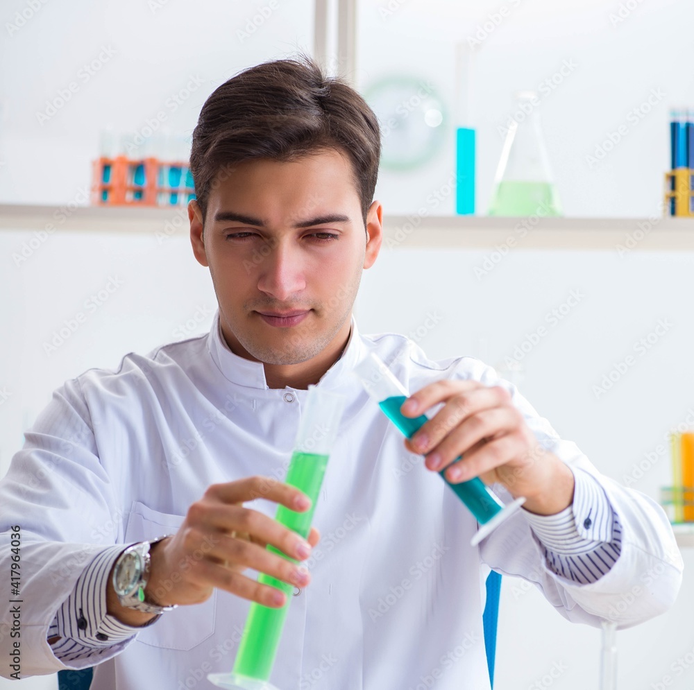 Young chemist student working in lab on chemicals Young chemist student working in lab on chemicals