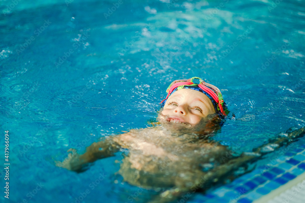 Toddler swimming training in the pool. Swimming training for a child. Development of children's sports. Strengthening baby's health.
