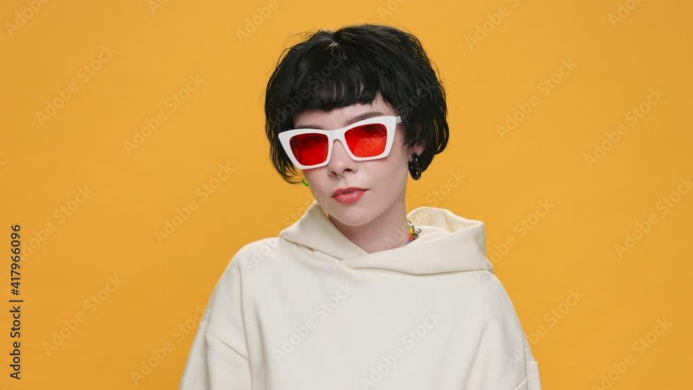 Think about gesture with index finger to temple of head Young teenager girl showing emotion with your head, Really? in Sunglasses on yellow background. Fashion. Monotone. Emotions People. Lifestyle Think about gesture with index finger to temple of head Young teenager girl showing emotion with your head, Really? in Sunglasses on yellow background. Fashion. Monotone. Emotions People. Lifestyle