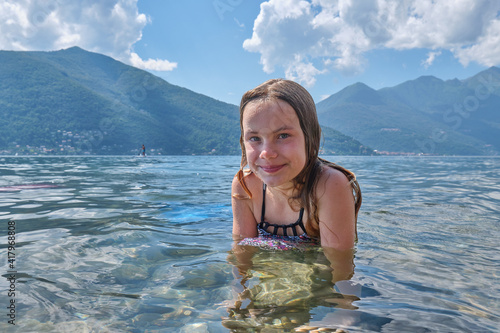 8 year old girl wearing a mermaid dress during a sunny summer day at the Lake Maggiore (Lombardei) in Italy.
