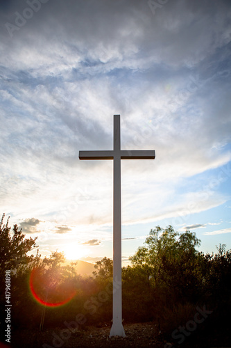 Sunlight bursts behind a mountain top cross of Jesus during golden hour at sunrise on Easter Morning 02