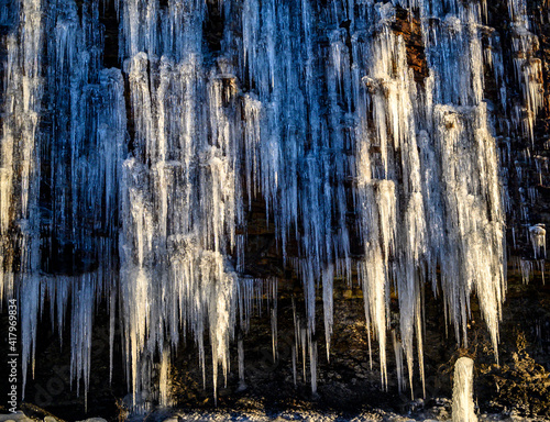 Icicles hanging on rocks, lighted by the sun. photo