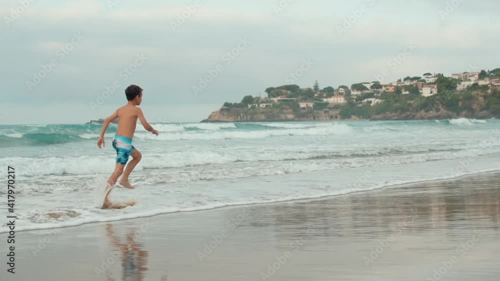 Active boy resting at coastline. Happy teenager running at sand beach. Active boy resting at coastline. Happy teenager running at sand beach.