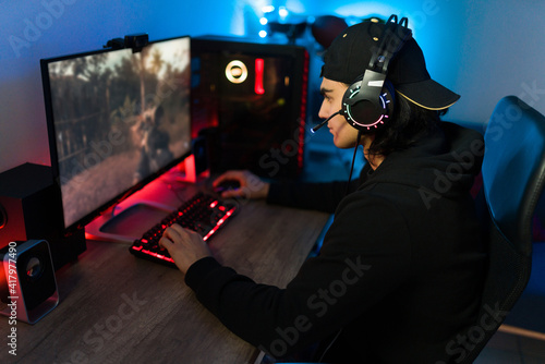 Latin man on a leisure day having fun with a gaming PC