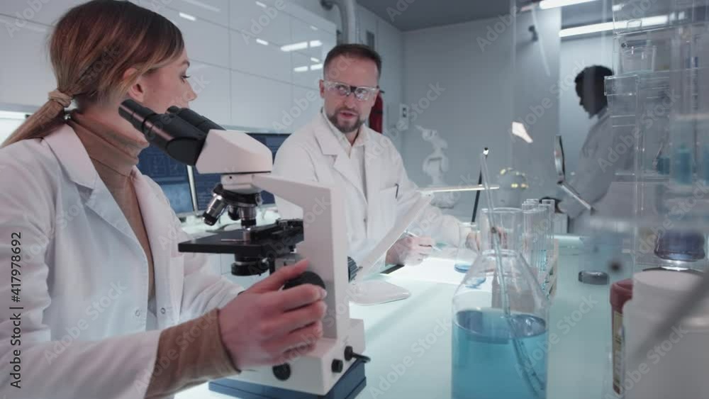Diverse scientists studying medical samples. Using computers and microscopes. Modern laboratory interior Diverse scientists studying medical samples. Using computers and microscopes. Modern laboratory interior