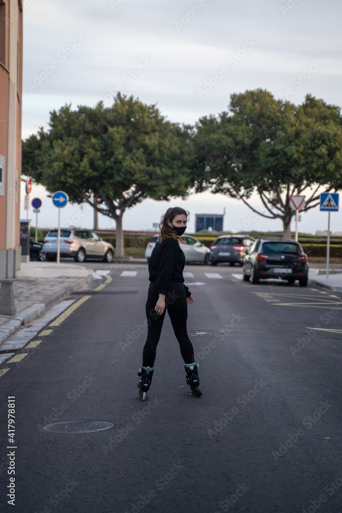 Caucasian girl wearing a mask looking at the camera while wearing roller skates in Palma de Mallorca, Spain