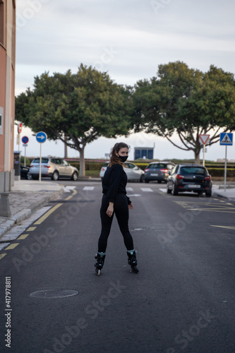 Caucasian girl wearing a mask looking at the camera while wearing roller skates in Palma de Mallorca, Spain