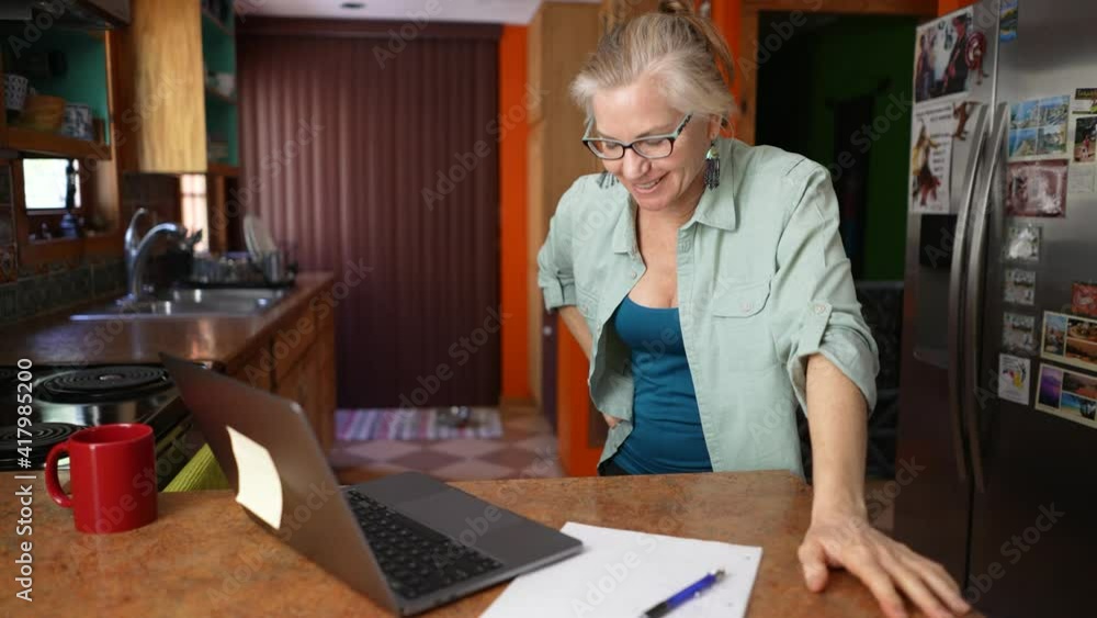 Slow motion of mature successful woman celebrates victory triumph looking at laptop video chat. Concept of female success businesswoman teacher tutor. Slow motion of mature successful woman celebrates victory triumph looking at laptop video chat. Concept of female success businesswoman teacher tutor.