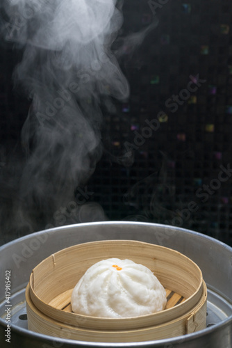 Steamed meat bun on hot steam pot, Hot steamed pork bun in bamboo steamer container.