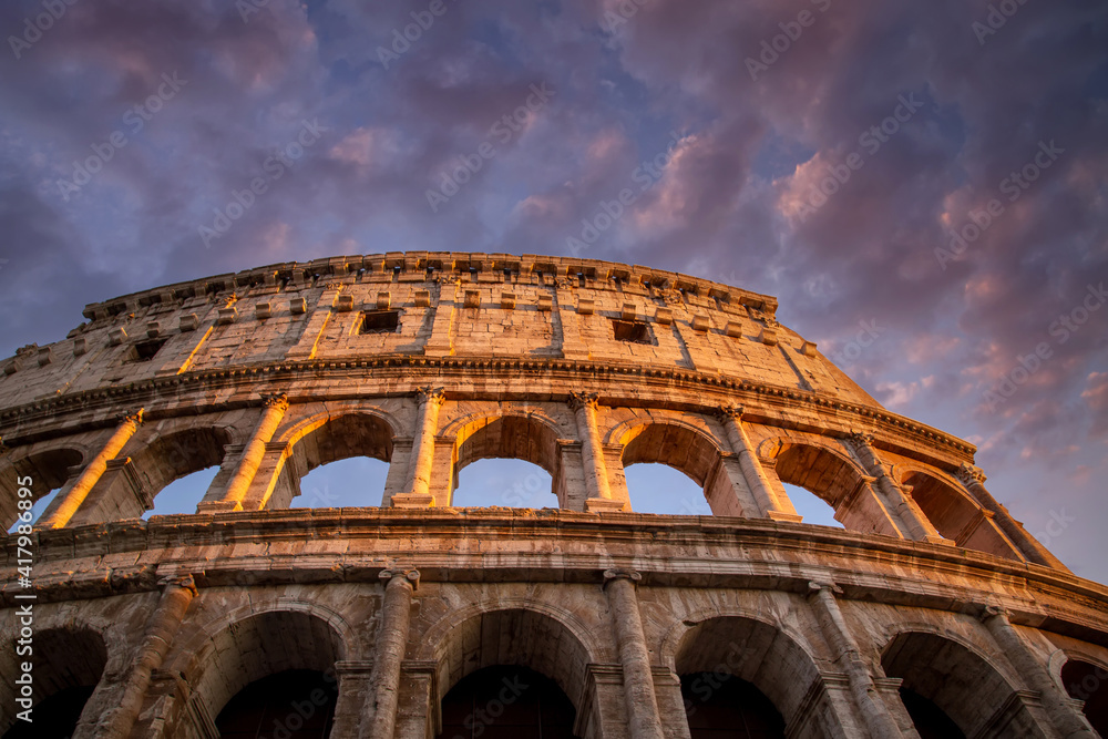 Famous Coliseum (Colosseum) of Rome at early sunset.