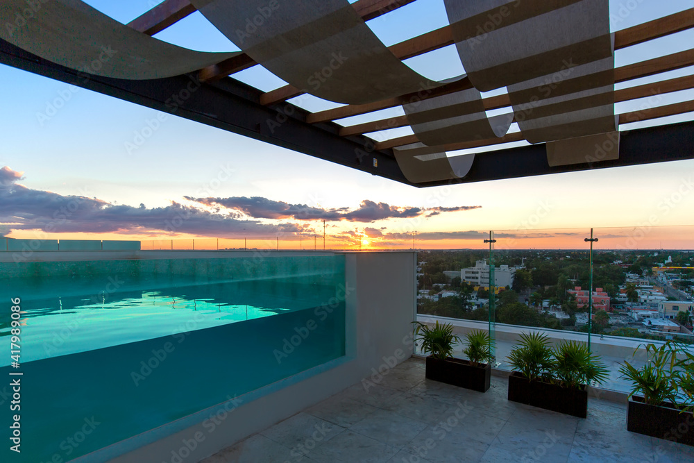 A swimming pool at the roof of the upscale hotel in Merida with scenic views over Merida cityscape and Paseo Montejo.