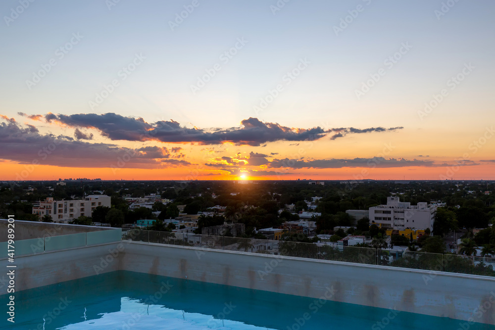 A swimming pool at the roof of the upscale hotel in Merida with scenic views over Merida cityscape and Paseo Montejo.