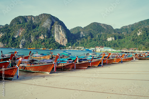 Beautiful landscape with traditional longtail boats, rocks, cliffs, tropical beach. Phi Phi Don Island, Thailand.