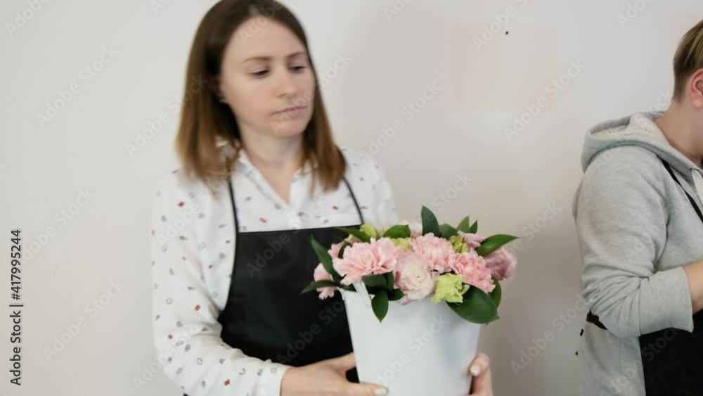 florist woman makes floral design. The practice of making beautiful flower bouquets by young professionals. Work in a flower shop. preparation for a holiday, wedding, anniversary florist woman makes floral design. The practice of making beautiful flower bouquets by young professionals. Work in a flower shop. preparation for a holiday, wedding, anniversary