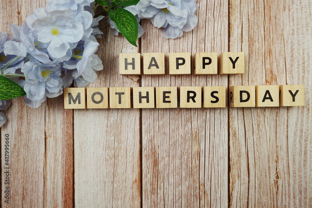 Naklejka premium Happy Mothers day alphabet letter with flower decoration on wooden background