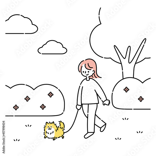 犬と公園を散歩する女性