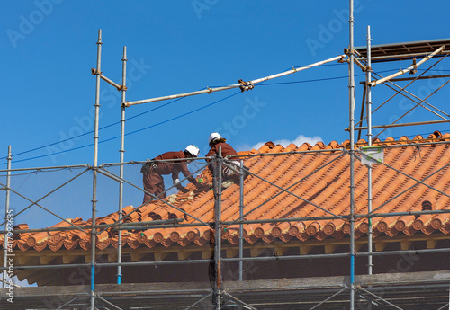 屋根の補修をしている建設作業員